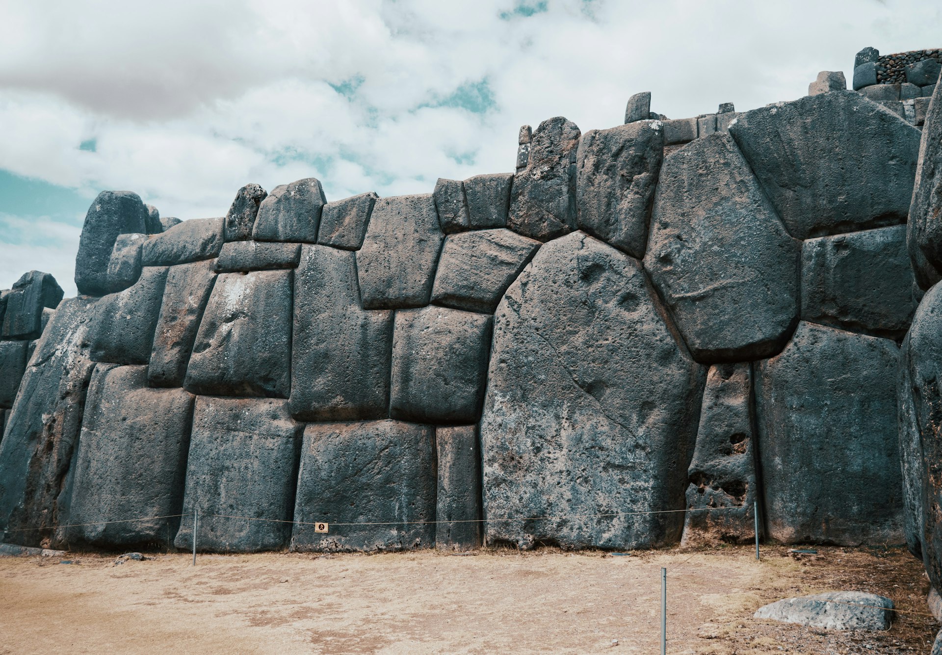 a stone wall made of rocks with a sky in the background